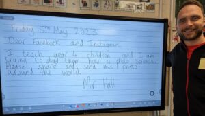 Young teacher standing by a whiteboard with a date and request to share the image on social media written on it