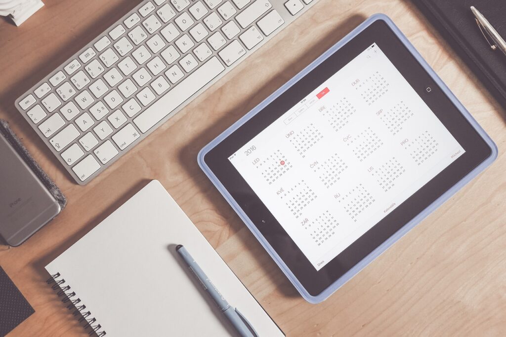 Photograph of a computer workstation with a calendar app open.